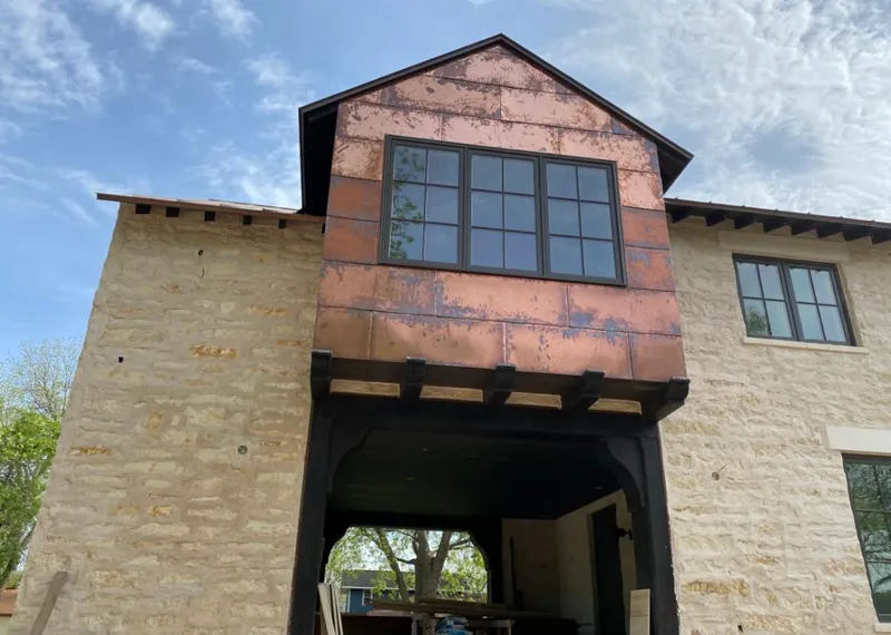 Copper metal panel facade on a stone building for Roof Repair in Corbin